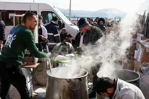 Tình nguyện viên phát các bữa ăn nóng cho người tị nạn ở Thổ Nhĩ Kỳ sau thảm hoạ động đất. Ảnh: REUTERS