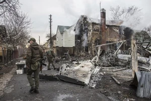 Binh sĩ Ukraine bên những mảnh vỡ của một chiếc máy bay bị bắn rơi ở Kiev, Ukraine ngày 25-2. Ảnh: AP