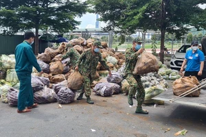 Các chiến sĩ bộ đội cùng lực lượng của phường đang khẩn trương vận chuyển lương thực, thực phẩm đến những người dân cần được hỗ trợ cấp thiết tại phường 13, quận Bình Thạnh. Ảnh: HC