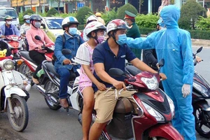 TP.HCM: Vui vẻ đo thân nhiệt khi qua chốt cầu Phú Long