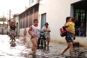 TP.HCM: Sau mưa, người dân bì bõm lội nước cống đen ngòm