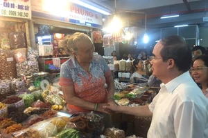 Bí thư Nguyễn Thiện Nhân mua mứt me ở chợ An Đông