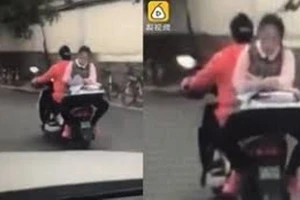 Clip: Nữ sinh ngồi ngược sau xe máy làm bài tập