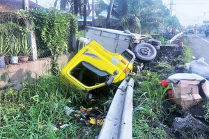 Xe tải nổ bánh, tông gãy rào chắn lao xuống kênh