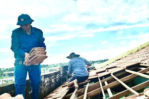 Lực lượng dân quân hỗ trợ giúp dân sửa chữa căn nhà bị tốc mái