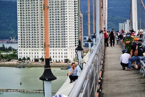 Người đàn ông ngồi 11 tiếng trên lan can cầu, dọa nhảy xuống