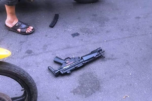 1 người nằm bất động và 1 khẩu súng vứt lại sau hỗn chiến