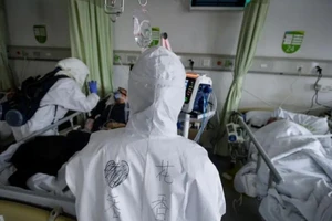 Nhân viên y tế mặc đồ bảo hộ chăm sóc bệnh nhân nhiễm virus Corona tại một phòng cách ly một bệnh viện ở Vũ Hán ngày 6-2. Ảnh: REUTERS