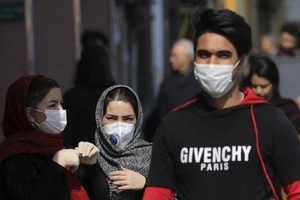 Người đi đường ở Tehran đeo khẩu trang ngừa dịch. Ảnh: AP