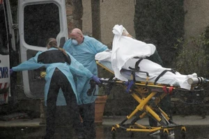 Di chuyển bệnh nhân COVID-19 trong mưa lớn tại trung tâm chăm sóc y tế Life Care ở TP Kirkland thuộc quận King, bang Washington (Mỹ). Ảnh: REUTERS