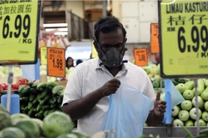 Mang khẩu trang mua đồ siêu thị ở thủ đô Kuala Lumpur (Malaysia) ngày 15-3. Ảnh: REUTERS