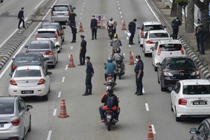 Cảnh sát kiểm soát đi lại người dân trên đường phố thủ đô Kuala Lumpur (Malaysia). Ảnh: AP