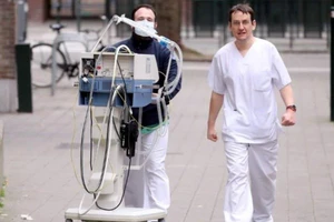 Nhân viên y tế di chuyển một máy trợ thở trong khuôn viên một bệnh viên ở thủ đô Brussels (Bỉ) ngày 20-3. Ảnh: REUTERS