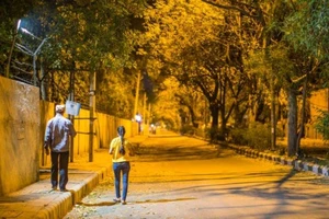 Cha và con gái trên đường phố vắng ở New Delhi (Ấn Độ) khuya 24-3. Ảnh: GETTY IMAGES