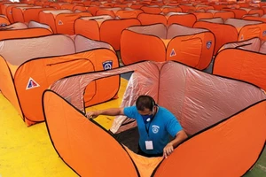 Dựng lều cách ly người nghi nhiễm trong một sân bóng rổ ở thủ đô Manila (Philippines) trong bối cảnh các bệnh viện quá tải. Ảnh: INQUIRER