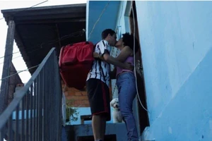 Anh Thiago hôn tạm biệt vợ trước khi bươn ra đường làm công việc giao hàng mùa COVID-19. Ảnh: REUTERS