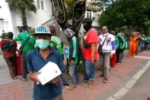 Xếp hàng nhận thực phẩm phát từ thiện từ một nhà hàng ở Jakarta (Indonesia) ngày 2-4. Ảnh: REUTERS 