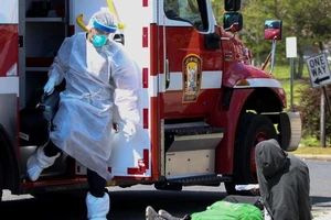Nhân viên phản ứng nhanh chuẩn bị hỗ trợ một bệnh nhân COVID-19 ở bang Washington (Mỹ) ngày 8-4. Ảnh: REUTERS