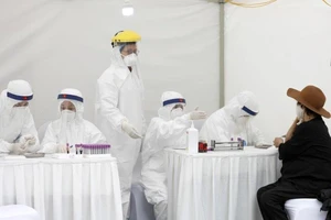 Một phụ nữ lớn tuổi được lấy mẫu xét nghiệm tại một trung tâm xét nghiệm nhanh COVID-19 ở Hà Nội tháng trước. Ảnh: EPA