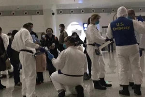 Nhân viên sứ quán Mỹ hỗ trợ công dân bị kẹt ở Vũ Hán về nước hồi tháng 2. Ảnh: WASHINGTON POST