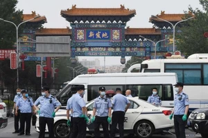 Cảnh sát canh gác bên ngoài khu chợ Xinfadi ở Bắc Kinh ngày 13-6. 