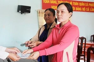 Hai người nhặt được vàng nhận tiền chia vàng từ chính quyền xã Phước Hưng.