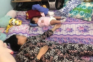 Sau khi sinh bị liệt nửa người, chị T. gặp nhiều bất tiện trong cuộc sống và chăm sóc con. Ảnh: HL