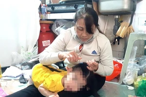 Bà Nguyễn Thu Thủy đang chăm sóc cháu nội. Ảnh: NGUYỄN HIỀN