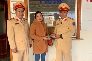 Đại diện CSGT huyện Tuy Đức trao lại tài sản cho người đánh rơi. Ảnh: Q.MINH