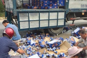 Người dân giúp tài xế thu gom bia rơi xuống đường