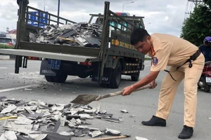 CSGT Bình Dương nhặt hàng trăm viên ngói rơi trên đường