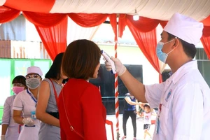 Đo thân nhiệt khách dự đám cưới của cô dâu Việt và chú rể Hàn