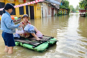 Nước lũ bủa vây phố cổ Hội An, người dân chèo bè đi mua đồ ăn sáng.