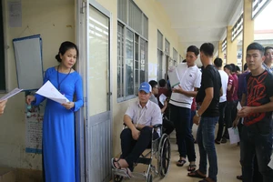 Thí sinh ngồi xe lăn đến làm thủ tục thi