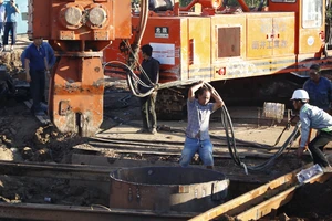 Chuẩn bị lấy đất xung quanh trụ bê tông có bé trai bị mắc kẹt