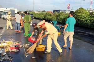 CSGT quận 12 cùng người dân thu gom cá giúp chủ xe gặp nạn 