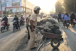 CSGT đẩy xe cút kít đổ bùn đất cho dân khỏi trượt