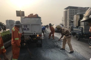 Xe tải vô danh thả đá sỏi tràn cầu vượt Quang Trung