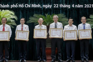 Lãnh đạo báo Pháp luật TP.HCM (bìa phải) nhận bằng khen của Chủ tịch UBND TP.HCM. Ảnh: NGUYỆT NHI