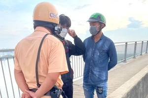 CSGT TP.HCM tiếp cận ngăn cản thanh niên định nhảy cầu Phú Mỹ. Ảnh: NSG