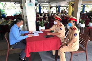 Đội CSGT Tân Sơn Nhất cho chủ quán nhậu ký cam kết. Ảnh: MINH VƯƠNG