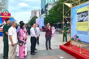 Các đại biểu tham quan triển lãm ảnh. Ảnh: NGUYỄN BÍCH