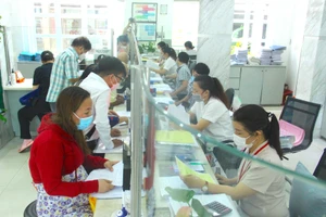 Cán bộ quận 1 đang giải quyết thủ tục cho người dân. Ảnh: LÊ THOA