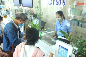 Cán bộ quận Bình Tân giải quyết hồ sơ cho người dân. Ảnh: LÊ THOA
