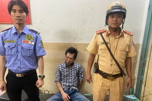 Đại úy Trần Hoài Nam, cán bộ Đội CSGT Bến Thành đưa người đàn ông về trụ sở công an phường. Ảnh: PC08