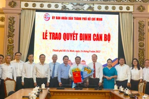 Phó Bí thư Thành uỷ TP.HCM Nguyễn Hồ Hải trao quyết định cho ông Trần Phi Long. Ảnh: BÍCH NGỌC