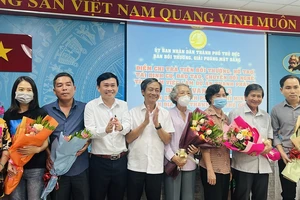 Ông Võ Trung Trực, Phó Giám đốc Sở TN&MT và ông Nguyễn Hữu Anh Tứ, Phó Chủ tịch UBND TP Thủ Đức trao hoa cho các tổ chức, cá nhân nhận tiền bồi thường dự án vành đai 3 sáng ngày 8-5. Ảnh: ĐÀO TRANG