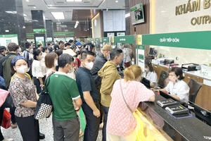 Người dân xếp hàng đăng ký khám chữa bệnh tại BV Bạch Mai (Hà Nội). Ảnh: THANH THANH