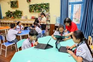 Cô Nguyễn Thị Ánh Nga (Phó Hiệu trưởng Trường Tiểu học Lê Đức Thọ, quận Gò Vấp) cùng các học sinh trong phòng thư viện thông minh. Ảnh: NGUYỆT NHI