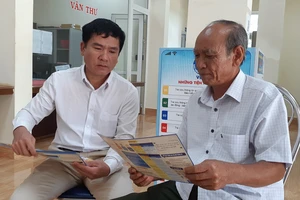 Nhân viên BHXH Việt Nam tuyên truyền người dân tham gia BHXH tự nguyện. Ảnh: V.LONG